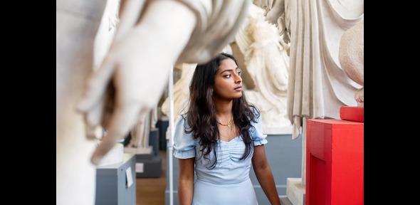 Student walking through statues at the Museum of Classical Anthropology, Cambridge Student walking through statues at the Museum of Classical Anthropology, Cambridge